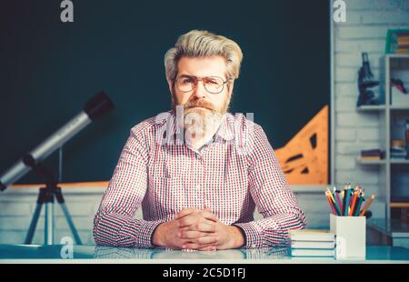 Teacher giving lesson to students in classroom Stock Photo
