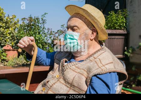 elderly man sitting alone on terrace during coronavirus epidemic quarantine Stock Photo