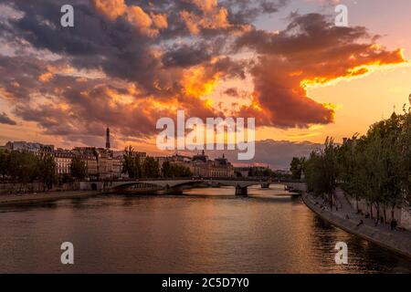 Paris, France - June 28, 2020: Nice view of Seine river, bridge and Eiffel tower in background at sunset in Paris. Viewed from Pont des Arts
