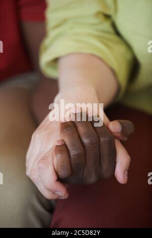 Close-up of young multiracial couple holding hands Stock Photo