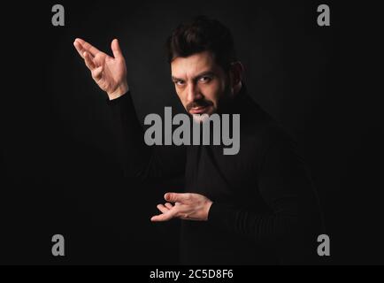 handsome bearded man posing over black studio background Stock Photo