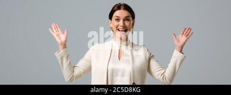 Panoramic shot of positive businesswoman looking at camera isolated on grey Stock Photo