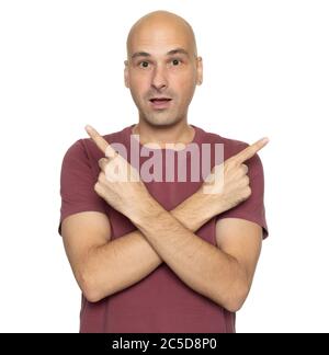 Puzzled bald man pointing different directions. Isolated on white studio background Stock Photo