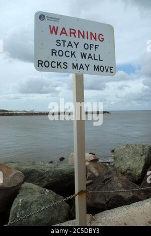 Warning Stay Off Rock Wall Rocks May Move sign, The Spit beach, Surfers Paradise, Gold Coast, Queensland, Australia. Stock Photo