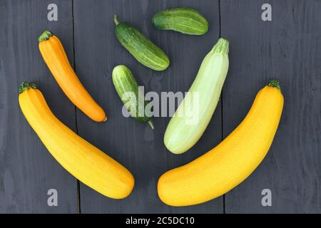 Summer squashes and cucumbers on wooden background. Gourds family Stock Photo