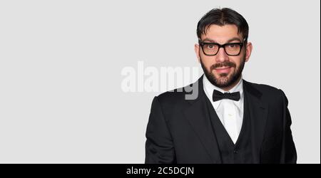 Handsome bearded man in tuxedo and glasses. Funny guy isolated on grey background Stock Photo