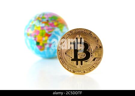 Bitcoin concept. World economy concept. New world currency. Golden coin bitcoin and globe. Stock Photo