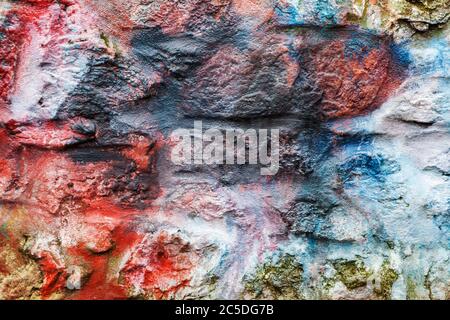 Old abstract red blue multi coloured painted stone brick wall texture background Stock Photo