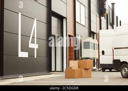 Image of big modern warehouse for parcels and loads with delivery van near the gate Stock Photo