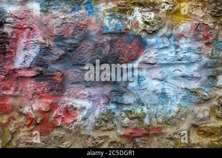 Old abstract red blue multi coloured painted stone brick wall texture background Stock Photo