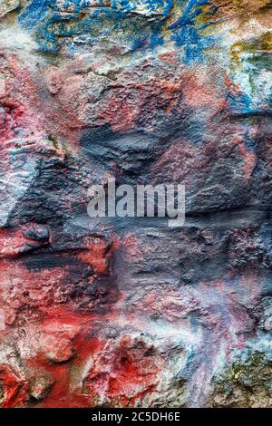 Old abstract red blue multi coloured painted stone brick wall texture background Stock Photo