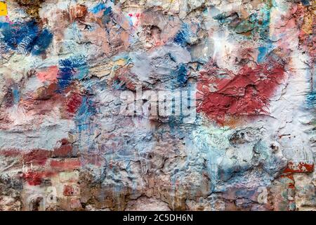 Old abstract red blue multi coloured painted stone brick wall texture background Stock Photo
