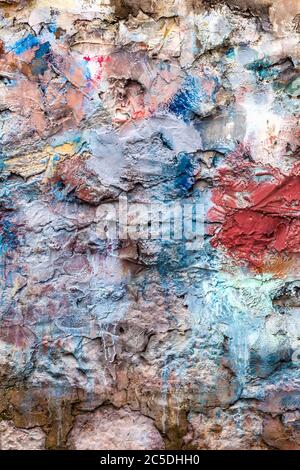 Old abstract red blue multi coloured painted stone brick wall texture background Stock Photo
