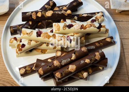 Three types of chocolate with dried fruits on the white background. Macro close of french chocolate. Fresh organic nut. Stock Photo