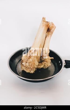 Raw stew beef bone soup in a pan isolated on white background. Stock Photo