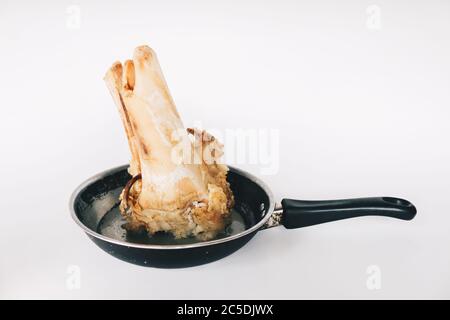 Raw stew beef bone soup in a pan isolated on white background. Stock Photo