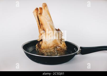 Raw stew beef bone soup in a pan isolated on white background. Stock Photo