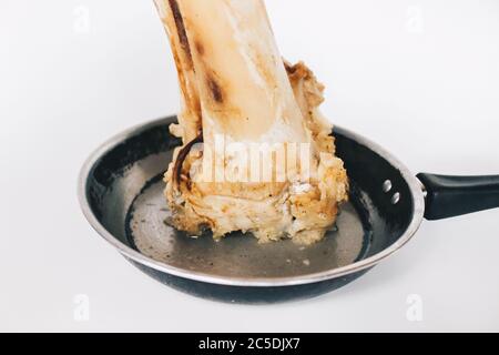 Raw stew beef bone soup in a pan isolated on white background. Stock Photo