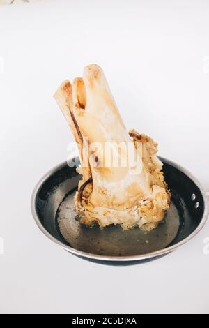 Raw stew beef bone soup in a pan isolated on white background. Stock Photo