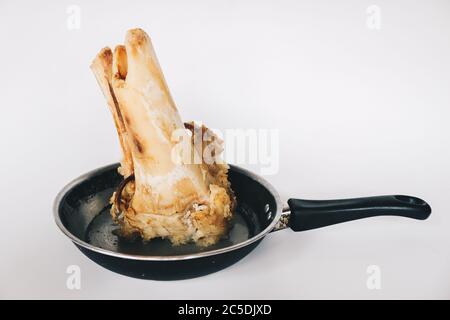 Raw stew beef bone soup in a pan isolated on white background. Stock Photo