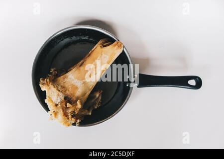 Raw stew beef bone soup in a pan isolated on white background. Stock Photo