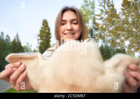 Close-up of happy girl holding dog by ears on summer day Stock Photo
