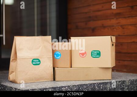 Close-up of cardboard boxes and packages on the ground before the door outdoors Stock Photo