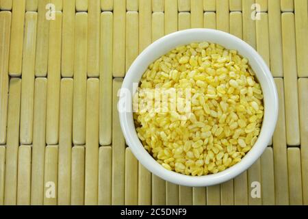 baked soybean in white cup on bamboo plate background Stock Photo