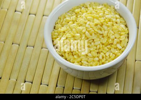 baked soybean in white cup on bamboo plate background Stock Photo