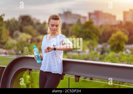 Sporty young woman checking running time progress on smart watch Stock Photo