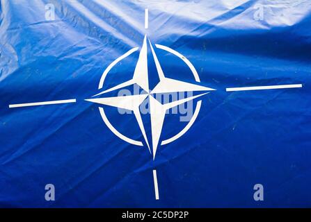 Ostrava, Czechia - September 18, 2016: Dirty and wrinkled blue canvas with flag of NATO ( North Atlantic Treaty Organization ). Military alliance Stock Photo