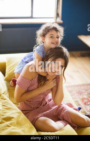Pretty girl hugging gorgeous mother. Young, beautiful mommy and daughter  smiling, happy together. Cheerful, joyful child and mom posing in light  room Stock Photo - Alamy