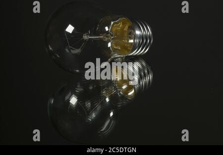 An old incandescent light bulb on black background