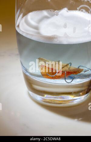 Hawley bow orthodontic teeth retainer in glass of denture cleanser Stock Photo