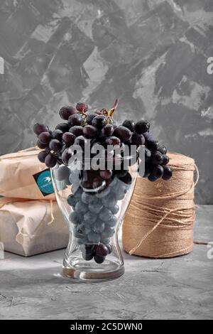 Bunches of fresh ripe red grapes on a concrete textural surface. Branch of pink grapes. Red wine grapes. dark grapes. Still life of food. Nature Stock Photo