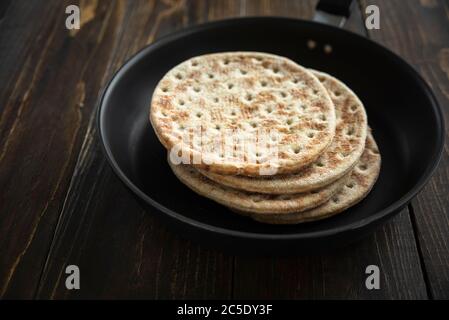 Stack of soft flatbread in pan on wooden table Stock Photo