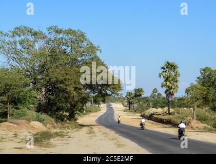 Motorcycles on the road at countryside in Myanmar, Southeast Asia. Wild land and small road and trees. Stock Photo