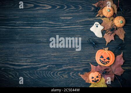 Halloween holiday background with cookies, leaves and spiders. View from above. Stock Photo