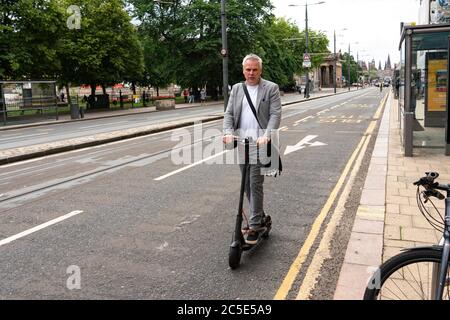 Edinburgh, Scotland, UK. 2 July, 2020. A man riding an electric scooter to travel along Princes Street in Edinburgh. Government is to allow trials on public roads in England of electric scooters this month. Currently their use is banned. Trials not scheduled in Scotland. Iain Masterton/Alamy Live News Stock Photo