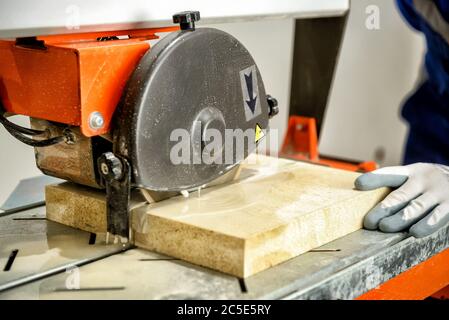 Worker cuts tile using a circular saw Stock Photo