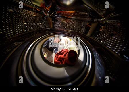 The man doing laundry. View from the inside of washing machine. Stock Photo