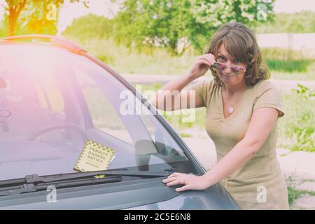 Unhappy woman looking at parking ticket Stock Photo