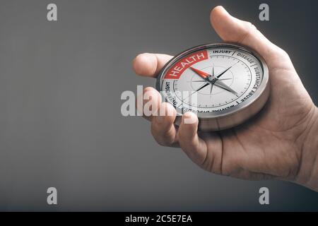Hand holding a compass with needle pointing the word health. Healthcare concept. Composite image between a hand photography and a 3D object. Stock Photo