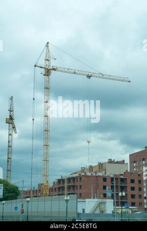 A crane on a construction site against a cloudy sky Stock Photo