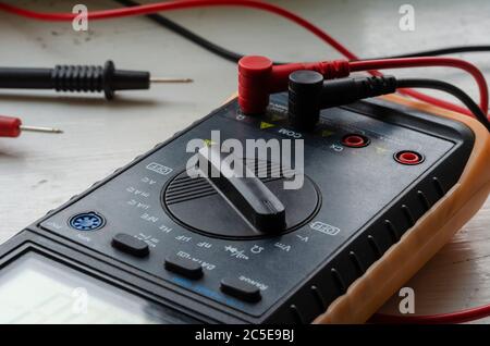 Close-up of a multimeter on a light background. Detailed shot of a measuring device. Qualified electrician services. Selective focus. Stock Photo