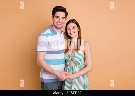 Portrait of his he her she nice attractive lovely pretty cute tender gentle sweet cheerful cheery couple holding hands enjoying isolated over beige Stock Photo
