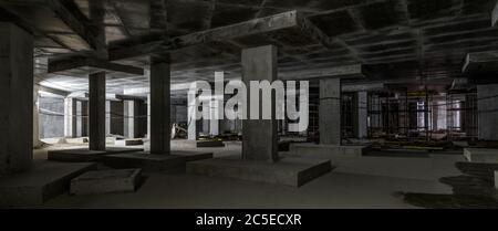 Concrete construction of basement of large building. Panorama inside the modern construction site in dark. Contemporary structure under construction w Stock Photo