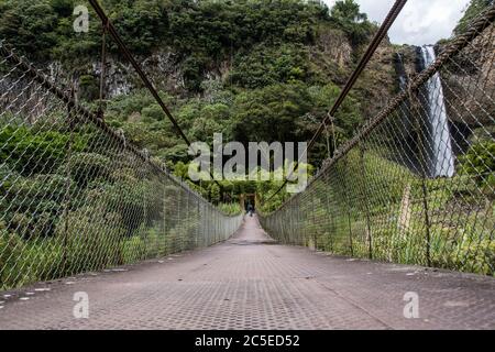 Suspension bridge connects the two sides of the  valley near Banos Stock Photo
