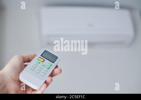 Remote control for air conditioner in hand. Room condition remote control. Air temperature switch for cooling of space. Stock Photo