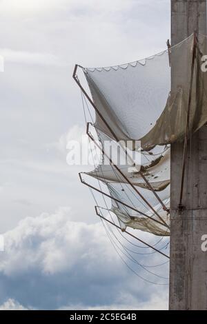 Mesh mounted on the wall of building under construction protect from falling fragments of metal reinforcement, cement stones other construction debris Stock Photo